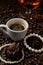 cup of coffee with a gift necklace and coffee beans in background and a red luxury box with jewelry.portrait mode.