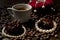 cup of coffee with a gift necklace and coffee beans in background and a red luxury box with jewlery.