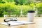 Cup of coffee with glassess and notepad on wooden table over green