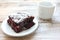 Cup of coffee with handmade chocolate cake on wooden table background. Brownie with cherries on a white plate.