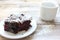 Cup of coffee with handmade chocolate cake on wooden table background. Brownie with cherries on a white plate.