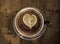 Cup of coffee with heart shape in it. made out of froth, wooden