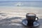 Cup of coffee latte on the beach