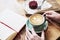 Cup of coffee latte on wooden table or background in woman hands from above. Having lunch in cafe.