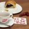 Cup of coffee with lipstick kiss, croissant and note