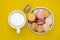 Cup of coffee and macaroons on colorfu lyellow background. top view