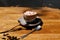 A cup of coffee with marshmallows on a wooden table background. A cocoa drink in a porcelain cup with a metal spoon.