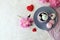 Cup of coffee with meringues, pink peony flowers, hearts on a light background