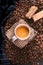 Cup of coffee in the middle of coffee beans with biscuits and tablecloth. Grained product. Hot drink. Close up. Harvesting. Natura