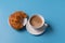 Cup of coffee with milk on blue background, with croissant, copy space for text