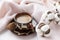 Cup of coffee with milk, candy, cotton twig, pink knitted fabric