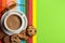 Cup of coffee with milk or cappuccino with cookies and cinnamon on colorful background. Drink with caffeine or cocoa