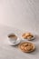 Cup of coffee with milk or cappuccino with cookies on light stone background. Drink with caffeine or cocoa with milk. Coffee