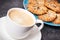 Cup of coffee with milk and fresh baked healthy oatmeal cookies. Delicious crunchy dessert