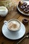 Cup of coffee,milk saucer and donuts, on wooden table with copy space