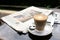 Cup of coffee with news paper on table