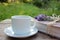 Cup of coffee and old book decorated with lavender flowers and tied with jute twine on wooden table.