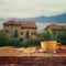 Cup of coffee on old wooden table in front of romantic Provence rural landscape. retro filtered image