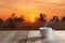 Cup of coffee over wood table and Sunset