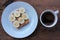 Cup of coffee and peanut butter banana toast on wooden background. Slices of whole wheat bran bread with peanut paste on a plate.