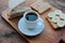 Cup of coffee and peanut butter banana toasts on wooden background. Slices of whole wheat bran bread with peanut paste on cutboard