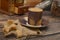 A Cup of coffee, pieces of brown sugar in a sugar bowl, coffee beans in a glass jar, a coffee grinder on a wooden background.