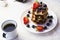 A cup of coffee and a plate of waffles and berries