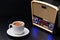 Cup of coffee and radio receiver on black background