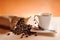 Cup of coffee and sack with coffee beans and orange background