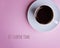 Cup of coffee on a saucer on a pale pink background.