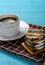 Cup of coffee and stack of sandwich biscuits with white cream filling vertical composition