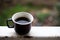 Cup of coffee stands on the railing in the garden