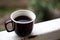 Cup of coffee stands on the railing in the garden