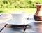 A cup of coffee stands on a wooden table in the garden.