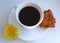 A cup of coffee with sugar, cookies and yellow dandelion flowers