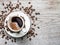 Cup of coffee surrounded by coffee beans. Top view.