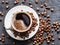 Cup of coffee surrounded by coffee beans. Top view.