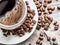 Cup of coffee surrounded by coffee beans. Top view.