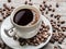 Cup of coffee surrounded by coffee beans. Top view.