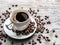 Cup of coffee surrounded by coffee beans. Top view.