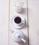 Cup of coffee, teapot and jug with milk in row over white wooden background. Flat lay, copy space