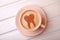 Cup of coffee with tooth on foam. Coffee spoils teeth and makes them yellow. coffee break