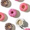 A cup of coffee and a variety of donuts on a white background. Flat lay composition with coffee and donuts