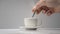 Cup of coffee, white background, hand turning