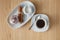 Cup of coffee, white rose, cinnamon on a wooden background