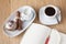 Cup of coffee, white rose, cinnamon on a wooden background