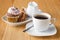 Cup of coffee, white rose, cinnamon on a wooden background