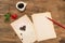 Cup of coffee with winged heart and pen on white sheet.