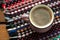 Cup of coffee on wooden background with textile hand-woven rag rug. Copy space, top view