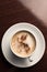 A cup of coffee on a wooden table top view